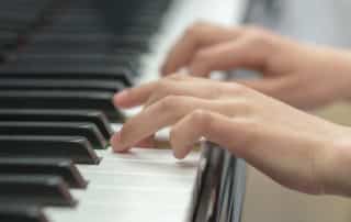 hands playing on piano