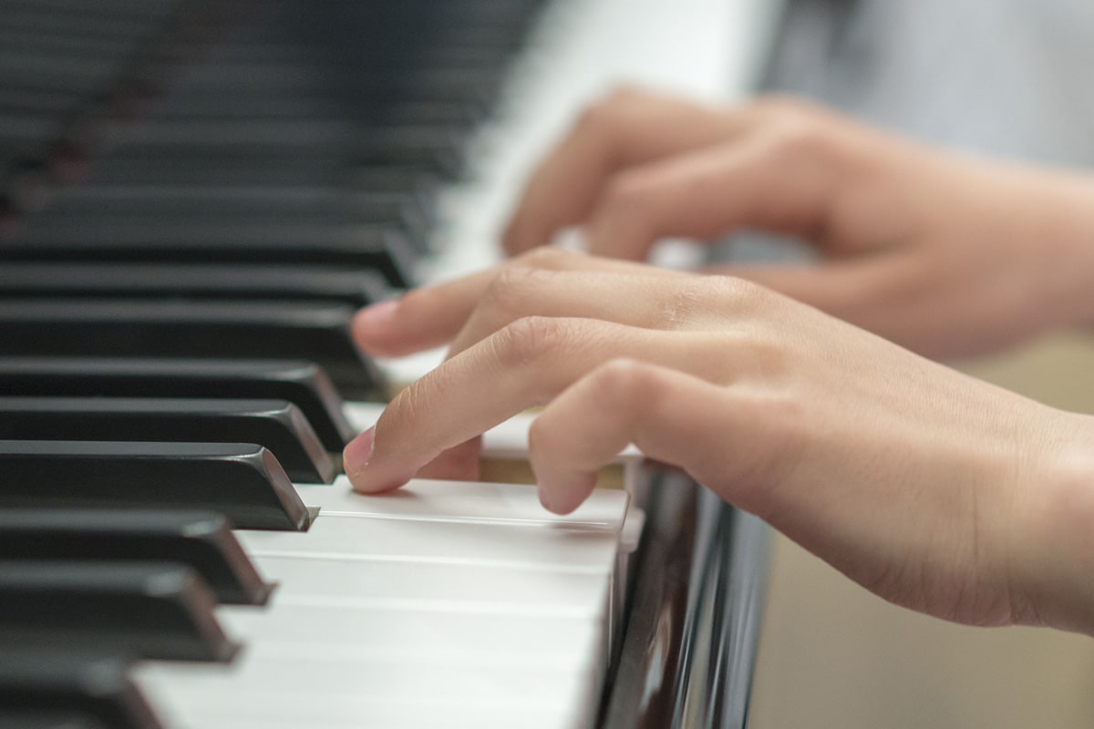 hands playing on piano